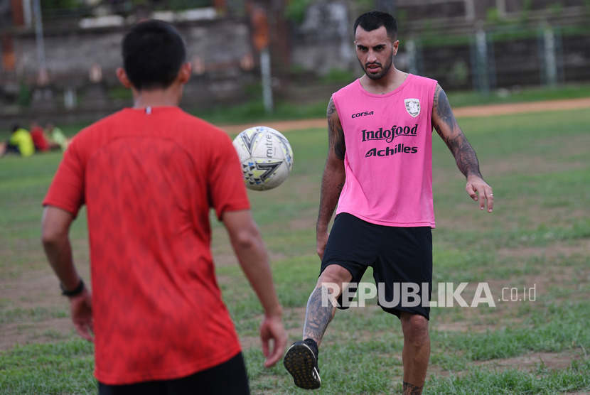 Pesepak bola Bali United Brwa Nouri (kanan) menendang bola ke rekannya Dias Angga Putra saat latihan ketahanan fisik di GOR Ngurah Rai, Denpasar, Bali.