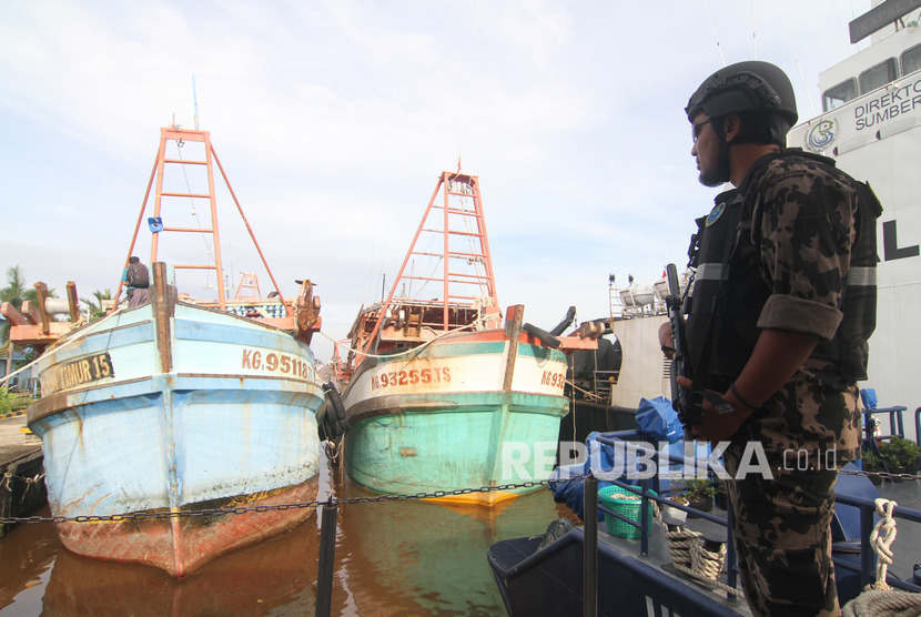 Seorang petugas Kapal Pengawas Kementerian Kelautan dan Perikanan bersiaga di sekitar kapal pencuri ikan (ilustrasi).