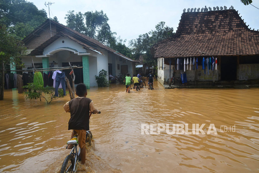 Sejumlah anak beraktivitas di dekat rumah yang terdampak banjir di Desa Kesambi, Mejobo, Kudus, Jawa Tengah, Ahad (12/1/2020). 