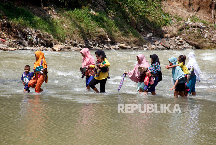 Sejumlah warga memaksakan diri untuk menyeberangi Sungai Cikaniki yang menghubungkan Desa Tonjong Rumpin dan Desa Kantalarang Leuwiliang di Rumpin, Kabupaten Bogor. (Ilustrasi)