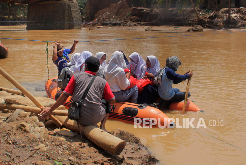 Jembatan Hanyut, Warga Lebak Menyeberang Pakai Perahu Karet. Sejumlah relawan membantu anak sekolah menyeberangi Sungai Ciberang dengan perahu karet di Sajira, Lebak, Banten.