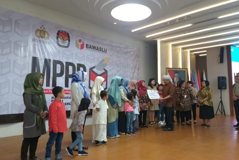 Ahli waris petugas badan ad hoc penyelenggara pemilu menerima santunan dari Masyarakat Peduli Penyelenggaraan Pemilu (MPPP) di gedung KPU RI, Jakarta Pusat, Kamis (16/1). 