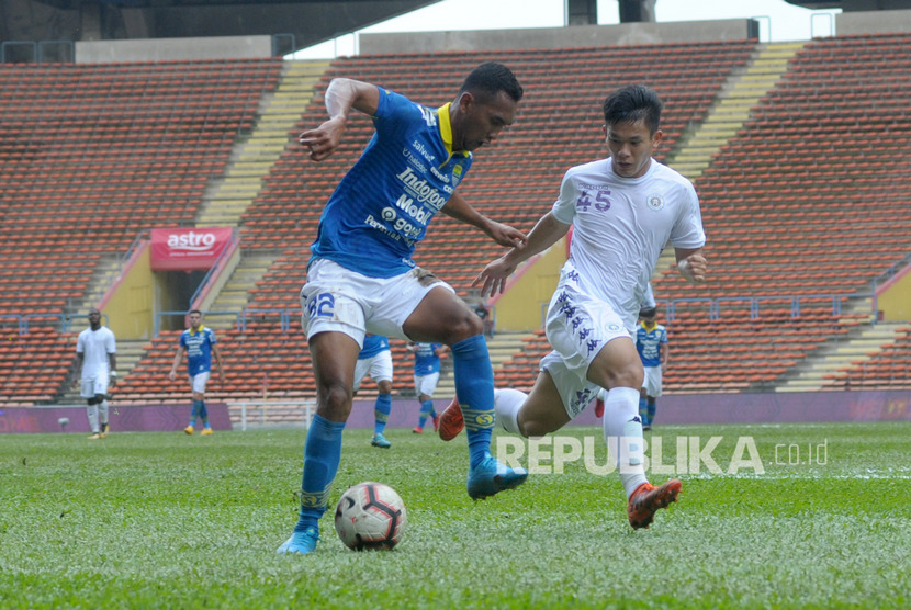 Pesepak bola Persib Bandung Beni Oktovianto (kiri) membawa bola dibayangi pesepak bola Hanoi FC Le Van Xuan (kanan) pada Kejuaraan Asia Challenge Cup 2020 di Stadion Shah Alam, Selangor, Malaysia, Ahad (19/1/2020). 
