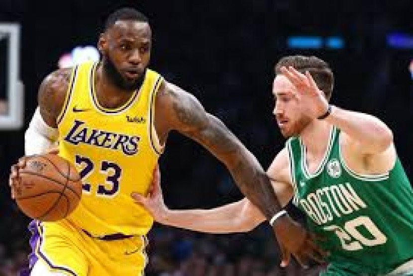 Bintang Los Angeles Lakers LeBron James membawa bola saat berhadapan dengan Boston Celtics dalam kompetisi basket NBA.