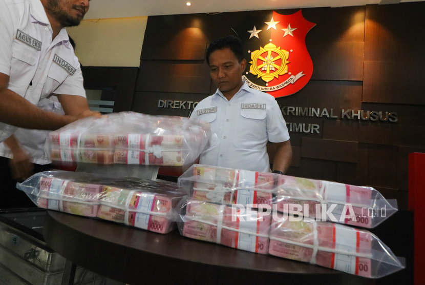 Polisi menunjukkan barang bukti uang rupiah saat ungkap kasus investasi ilegal MeMiles (Dok). 