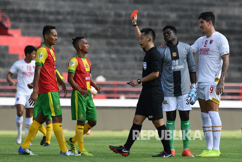 Wasit Chen Hsin Chuan (ketiga kanan) memberikan kartu merah kepada penjaga gawang Lalenok United Timor Leste Agbozo Nathaniel (kedua kanan) setelah menjatuhkan pesepak bola PSM Makassar Ferdinand Sinaga dalam pertandingan play off AFC Cup 2020 di Stadion I Wayan Dipta, Gianyar, Bali, Rabu (22/1/2020).