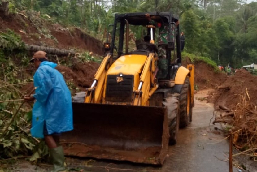 Petugas membersihkan material longsoran yang menutup akses Jalan Cikeusal-Warung Legok, tepatnya di Kepunduhan Sukalebar RT 29/6 Desa Pasirsalam, Kecamatan Mangunreja, Kabupaten Tasikmalaya, Rabu (22/1).