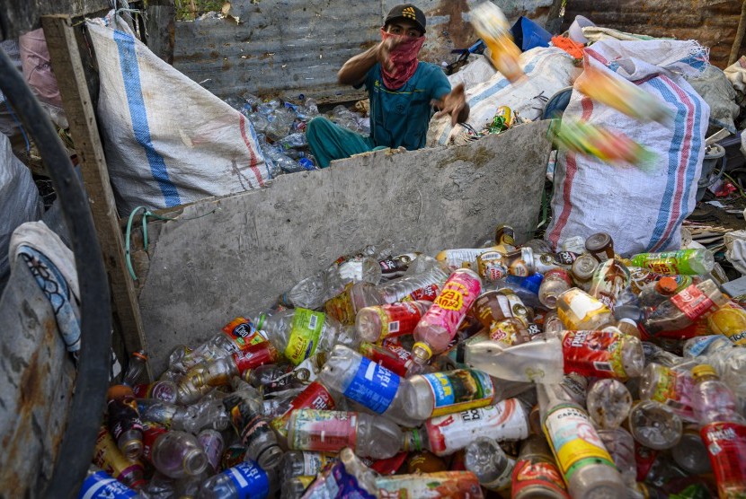 Seorang pemulung memilah sampah plastik yang dikumpulkannya untuk didaur ulang