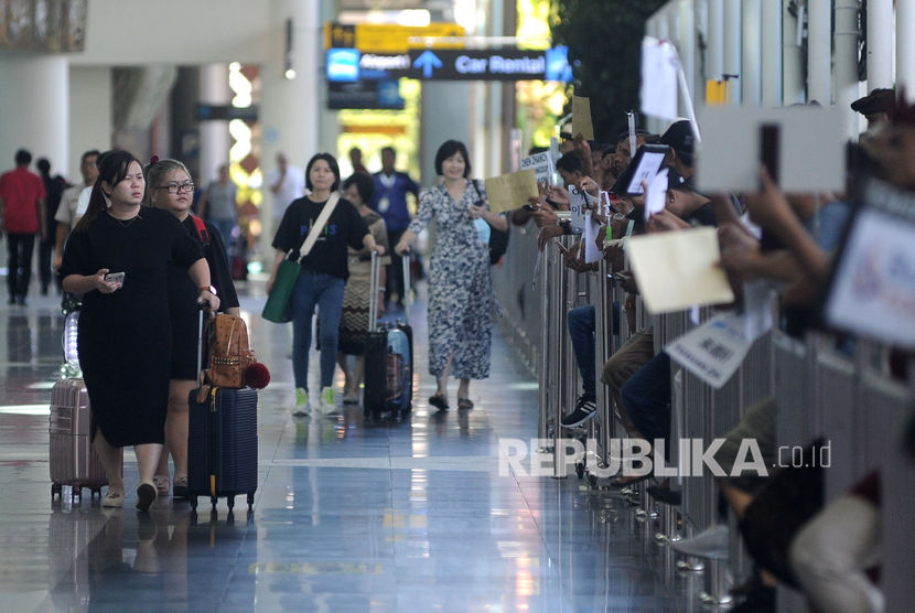 Sejumlah wisatawan membawa barang bawaan setibanya di Terminal Kedatangan Internasional Bandara Internasional I Gusti Ngurah Rai, Bali, Rabu (22/1/2020). 
