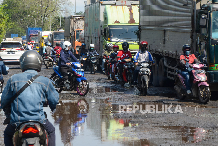 Sejumlah kendaraan melintasi jalan raya Kali Abang yang rusak di Bekasi, Jawa Barat, Kamis (23/1/2020).
