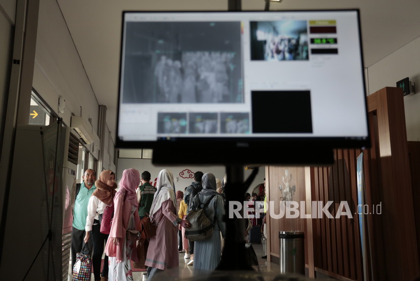 Petugas Kantor Kesehatan Pelabuhan Yogyakarta mengoperasikan alat deteksi suhu tubuh saat kedatangan penumpang dari Malaysia di Bandara Internasional Adisutjipto, Kamis (23/1/2020).