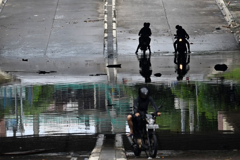 Pengendara sepeda motor menghentikan kendaraannya untuk menghindari banjir di Jalan Underpass Kemayoran, Jakarta, pekan lalu.