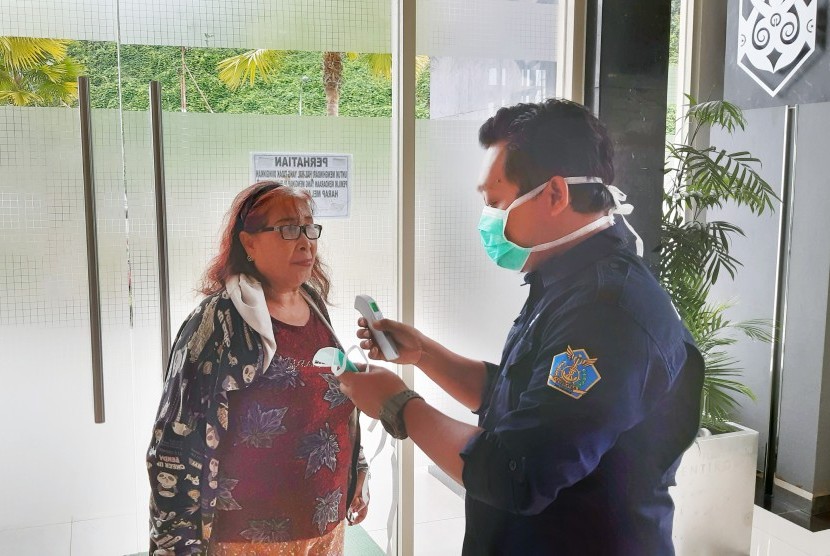 Seorang petugas Kantor Kesehatan Pelabuhan (KKP) Entikong mengukur suhu tubuh warga yang masuk dari Malaysia di Pos Lintas Batas Negara (PLBN) Entikong di Kabupaten Sanggau, Kalimantan Barat, Jumat (24/1). (ilustrasi)
