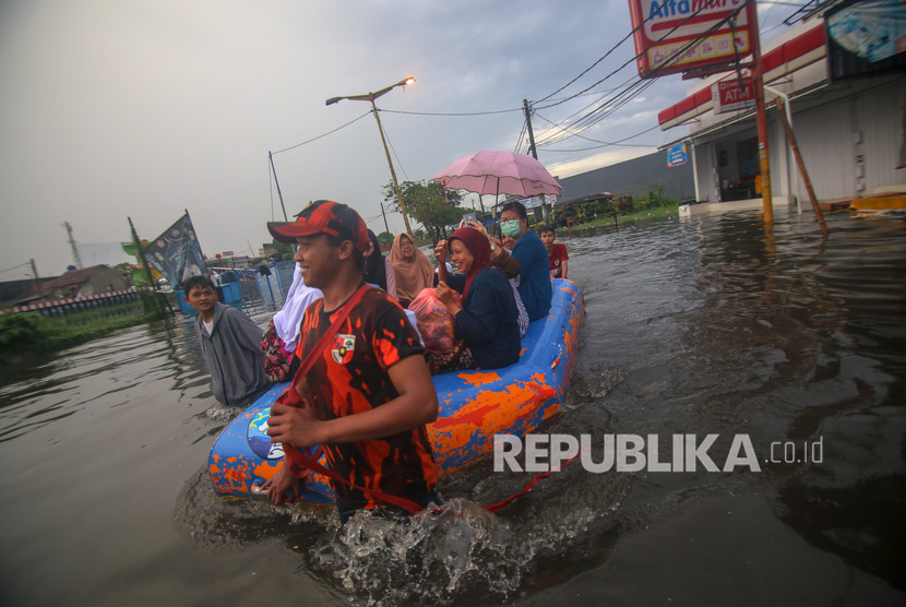 Warga melintasi banjir menggunakan perahu di Total Persada, Periuk, Kota Tangerang, Banten, Jumat (24/1/2020). 