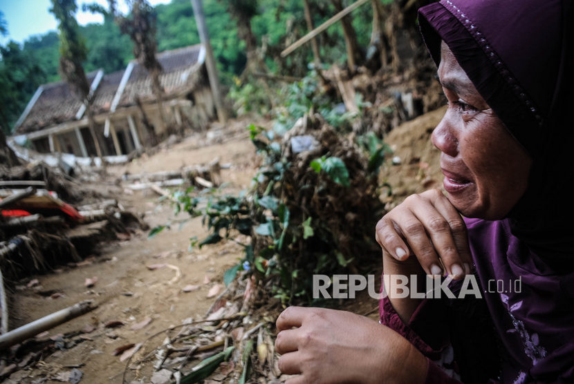 Seorang warga menangis saat melihat rumahnya yang rusak akibat diterjang banjir bandang di Kampung Susukan, Lebak, Banten, Ahad (26/1/2020). 