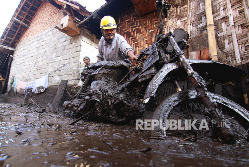 Warga mengevakuasi sepeda motornya yang terdampak banjir bandang di Sempol, Ijen, Bondowoso, Jawa Timur, Kamis (30/1/2020).