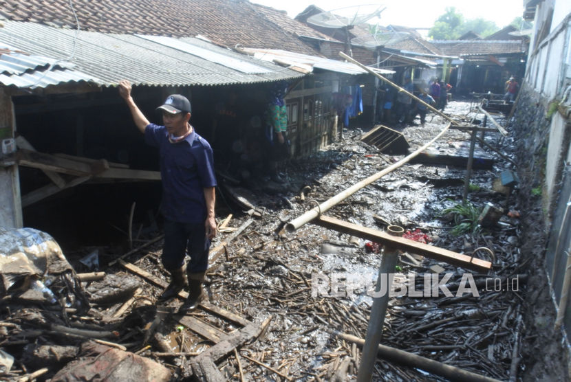 Warga berada di depan rumah yang terkena banjir bandang di Desa Kalisat, Kecamatan Ijen, Bondowoso, Jawa Timur, Kamis (30/1/2020). 