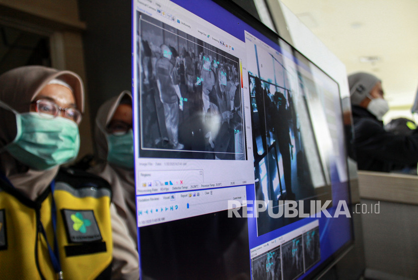 Petugas karantina kesehatan memeriksa penumpang dengan alat pendeteksi suhu tubuh (thermal scanner) di kedatangan terminal 2 Bandara Juanda Surabaya, Jawa Timur, Kamis (30/1/2020). (Antara/Umarul Faruq)