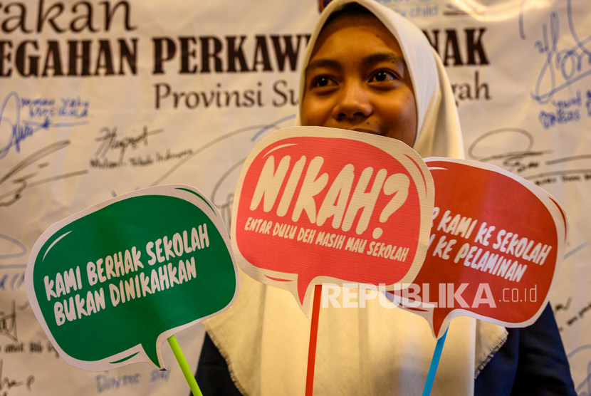 Seorang remaja putri membawa peraga kampanye pada Kick Off Gerakan Pencegahan Perkawinan Anak di Palu, Sulawesi Tengah. 