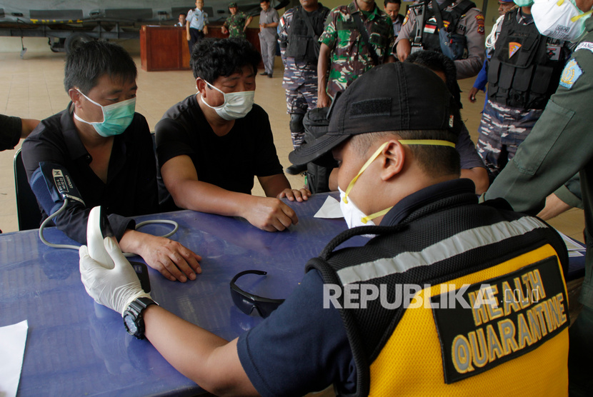 Petugas Karantina Kesehatan Pelabuhan (KKP) Kupang memeriksa kesehatan enam warga negara China yang terdampar di perairan Rote Ndao setibanya di Lantamal VII Kupang, NTT, Kamis (30/1/2020)