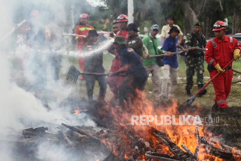Petugas Manggala Agni Daops Pekanbaru dibantu relawan mencoba memadamkan api pada simulasi pemadaman kebakaran hutan dan lahan (karhutla) di Pekanbaru, Riau, Kamis (30/1/2020).