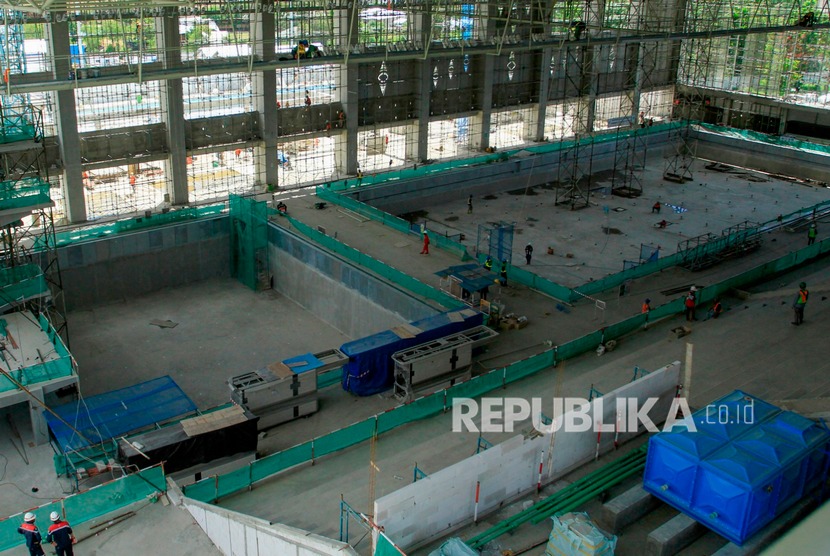 Pekerja menyelesaikan pembangunan venue Aquatic PON XX Papua. Komisi X DPR mendesak pemerintah menunda penyelenggaraan PON XX di Papua.