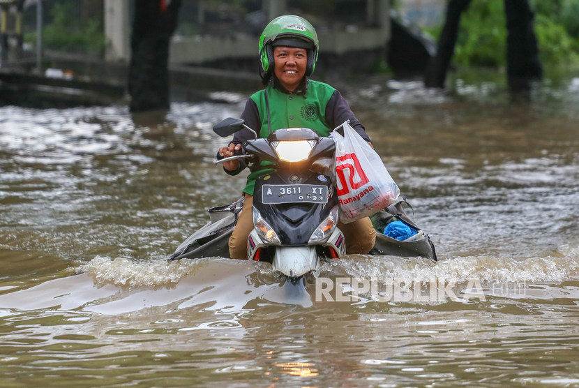 Pengendara melintasi banjir di Jalan Raya Regency, Kota Tangerang, Banten, Sabtu (1/2/2020).