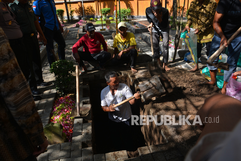 Warga dan santri menggali liang lahat di Pesantren Tebuireng, Jombang, Jawa Timur, Senin (3/2/2020).