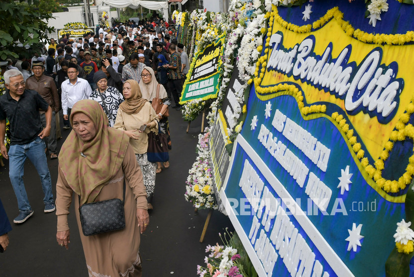 Sejumlah pelayat melintas di depan karangan bunga ucapan belasungkawa atas wafatnya KH Salahuddin Wahid atau Gus Sholah di rumah duka di kawasan Mampang Prapatan, Jakarta, Senin (3/2/2020).