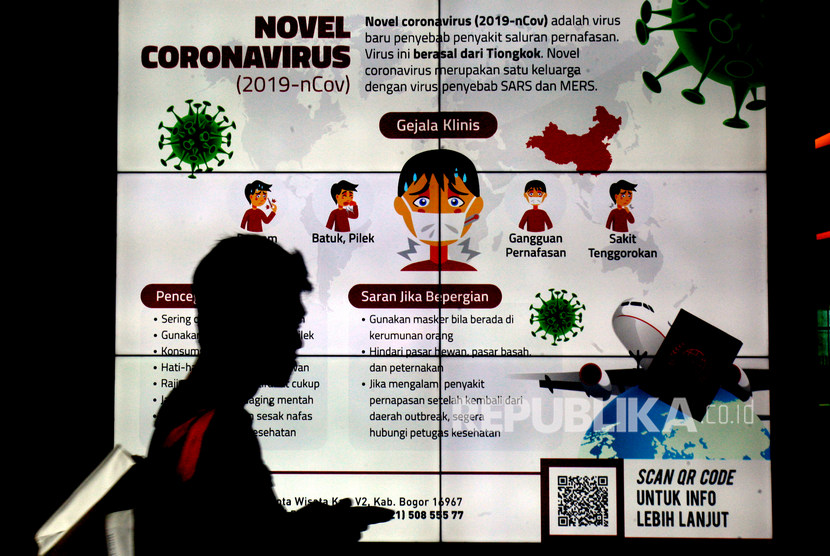 Warga melintas didepan videotron sosialisasi pencegahan virus corona. 