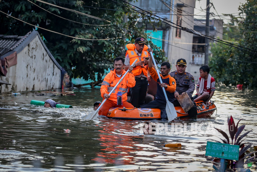 Petugas mengevakuasi warga terdampak banjir di Periuk Damai, Kota Tangerang, Banten, Senin (3/2/2020). 