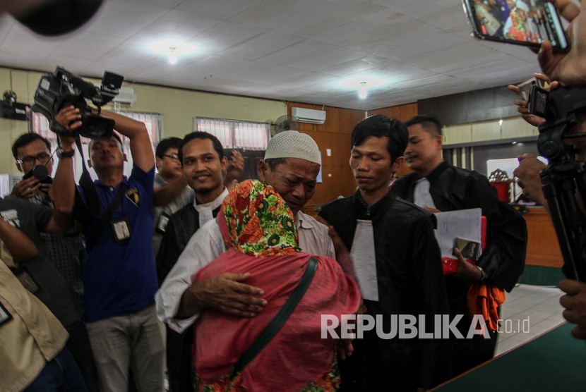 Petani pembakar lahan seluas 20x20 meter Syarifudin (68) memeluk istri usai pembacaan vonis oleh hakim dalam sidang putusan di Pengadilan Negeri Pekanbaru, Riau, Selasa (4/2/2020).