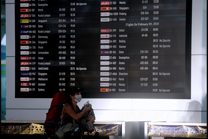 Penumpang melintas di dekat layar informasi penerbangan di Terminal Keberangkatan Internasional Bandara Internasional I Gusti Ngurah Rai, Bali, Selasa (4/2). (ilustrasi)