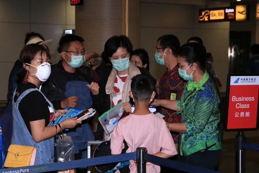 Petugas memeriksa tiket penumpang pesawat maskapai China Southern Airlines tujuan Guangzhou, China, di Terminal Keberangkatan Internasional Bandara Internasional I Gusti Ngurah Rai, Bali, Selasa (4/2/2020).