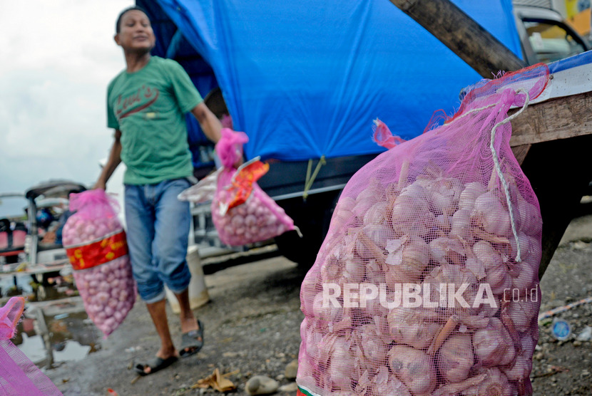 Pedagang membawa karung berisi bawang putih yang akan dijual di Pasar Minasa Maupa, Kabupaten Gowa, Sulawesi Selatan, Rabu (5/2/2020).