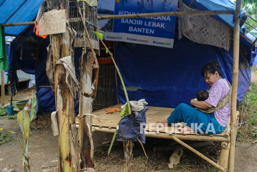 Seorang warga mengasuh anaknya di depan tenda pengungsian di Kampung Seupang, Lebak, Banten, Rabu (5/2/2020).