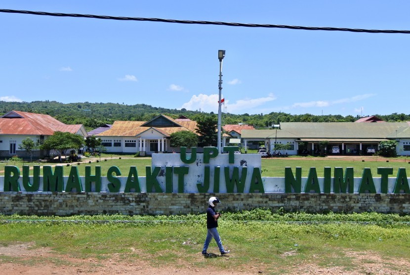 Seorang pria berjalan di depan papan nama RS Jiwa Naimata yang dipersiapkan menjadi tempat karantina bagi mahasiswa Timor Leste dari China yang akan menjalani masa observasi di Kupang, NTT, Kamis (6/2/2020). (Antara/Kornelis Kaha)