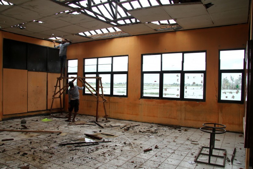 Pekerja melakukan pengerjaan perbaikan gedung sekolah yang rusak di SDN Samudrajaya 04, Kabupaten Bekasi, Jawa Barat, Kamis (6/2/2020).