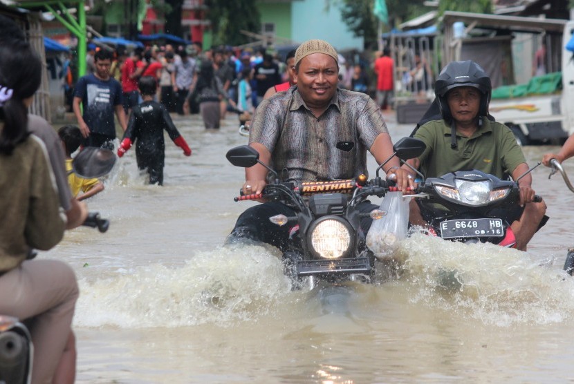 Warga melintasi genangan banjir di sejumlah wilayah di Kabupaten Cirebon, Jawa Barat.