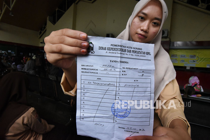 Warga memperlihatkan tanda terima permohonan pembuatan KTP (Kartu Tanda Penduduk) di Kantor Disdukcapil Kota Serang, Banten, Jumat (7/2/2020).