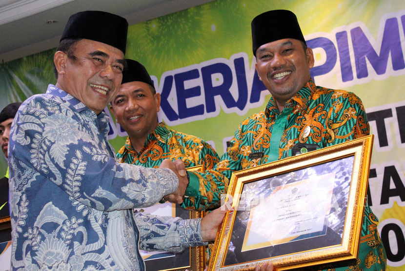 Menteri Agama Fachrul Razi (kiri) menyerahkan penghargaan kategori Punggawa Kerukunan kepada Kepala Kantor Kemenag Kapuas Hulu Syahrul (kanan) di acara Rapat Kerja Pimpinan (Rakerpim) Kanwil Kementerian Agama Kalbar di Pontianak, Jumat (7/2/2020).