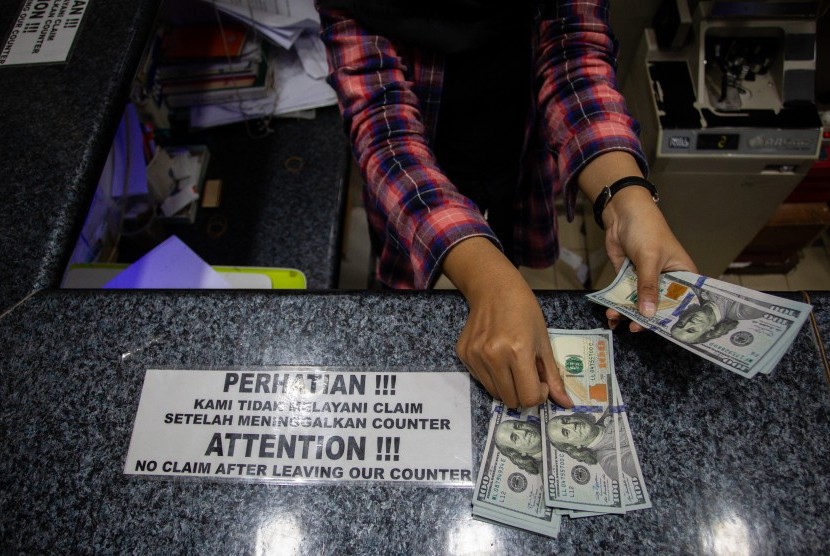 Petugas menghitung uang dolar AS di salah satu gerai penukaran mata uang asing di Jakarta, Jumat (7/2/2020). Indeks dolar naik 0,47 persen menjadi 102,5205 pada akhir perdagangan. 