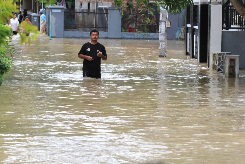 Warga melintasi banjir yang merendam di desa Wanakaya, Kecamatan Gunungjati, Cirebon, Jawa Barat