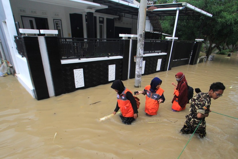 Warga melintasi banjir di Kabupaten Cirebon (ilustrasi). Banjir masih mengancam sejumlah wilayah di Kabupaten Cirebon. Hal itu seiring dengan potensi terjadinya hujan dengan intensitas sedang – lebat hingga akhir tahun nanti.