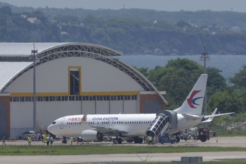 Sejumlah petugas berada di sekitar pesawat milik maskapai penerbangan China Eastern di area apron Bandara Internasional I Gusti Ngurah Rai, Bali, Sabtu (8/2/2020).