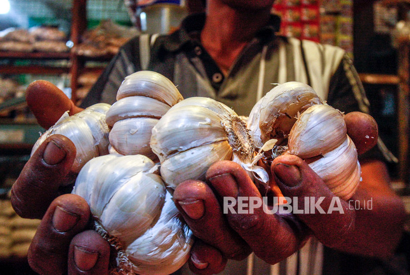 Pedagang menunjukan bawang putih yang dijualnya di Pasar Cibinong, Bogor, Jawa Barat, Selasa (11/2/2020). 