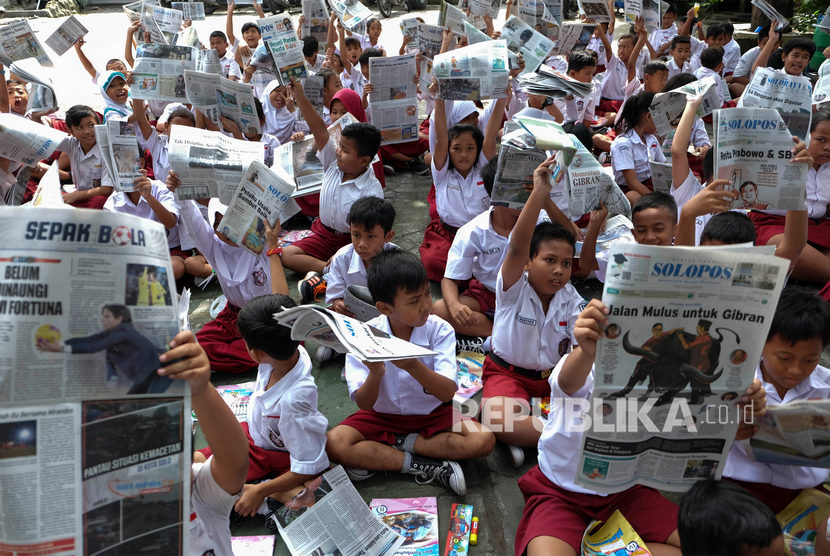 Sejumlah siswa SD Negeri Tugu Solo mengikuti kegiatan membaca koran bersama di halaman sekolah setempat, Solo, Jawa Tengah, Selasa (11/2/2020). 
