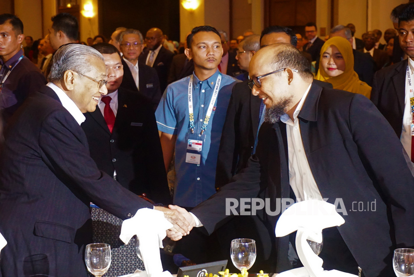 Perdana Menteri Malaysia Tun Dr Mahathir Mohamad berjabat tangan dengan penyelidik Komisi Pemberantasan Korupsi (KPK) Novel Baswedan saat menghadiri peluncuran Perdana International Anti-Corruption Champion Fund (PIACCF) di Putrajaya, Malaysia, Selasa (11/2/2020).