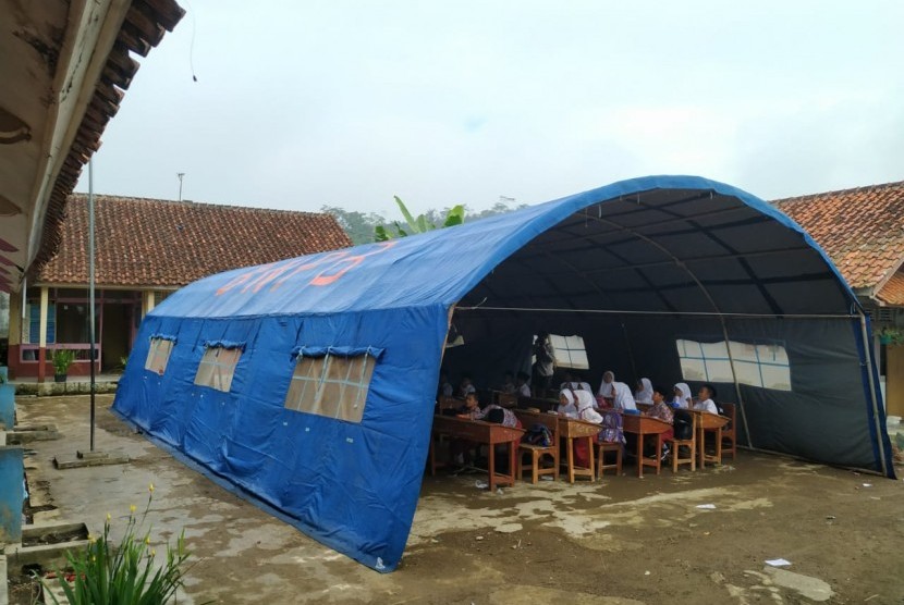 Para siswa SDN 3 Cigorowong, Kabupaten Tasikmalaya, belajar di tenda darurat, Rabu (12/2). Sejumlah siswa lainnya mesti belajar di atas lantai beralaskan karpet dalam ruang kelas.Proses KBM dipindahkan ke tenda darurat dilakukan sejak Selasa (11/2). 