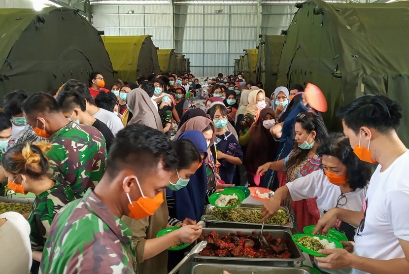 Sejumlah Warga Negara Indonesia (WNI) yang dievakuasi dari Wuhan, China mengambil makan di pusat observasi di Hanggar Pangkalan Udara TNI AU Raden Sadjad, Ranai, Natuna, Kepulauan Riau, Rabu (12/2/2020).